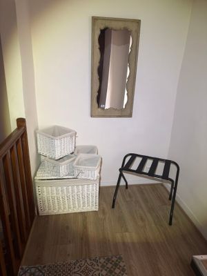 a picture of a hallway with a chair and a mirror