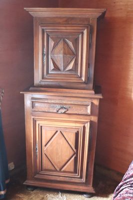 a wooden cabinet in the corner of a room