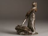 bronze statue of a woman with a dog on a rock