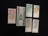 several different bank notes are laid out on a black surface