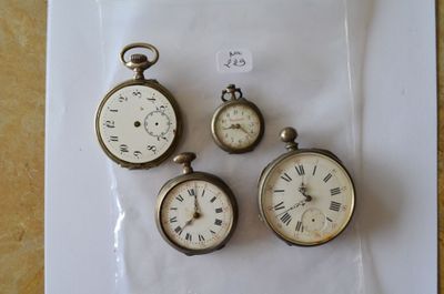 trois montres de poche anciennes sont posées sur un morceau de papier