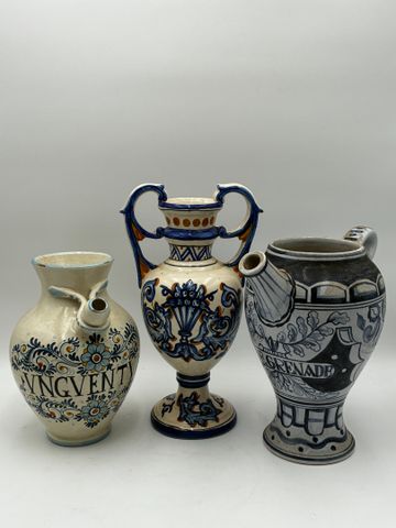 Deux verseuses et un vase de forme Médicis en faïence polychrome.