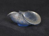 a small silver and blue bowl on a black surface