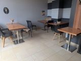 tables and chairs in a room with a clock on the wall