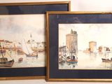 two framed paintings of boats in a harbor with a clock tower in the background
