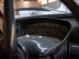 dashboard of an old car with a clock and steering wheel