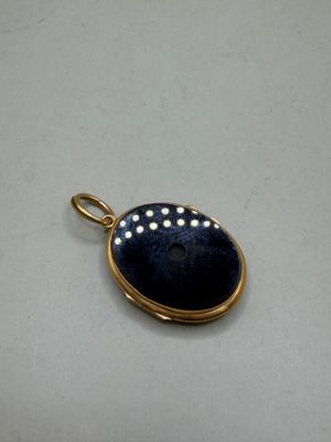 a close up of a pendant on a white surface