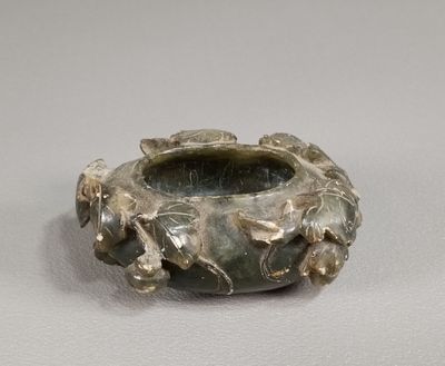 un vase en argent orné de feuilles, posé sur une table