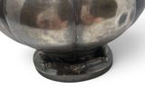 a silver vase on a stand on a white surface