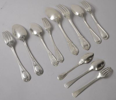 un grand nombre de cuillères et de fourchettes en argent disposées sur une table