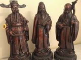 three asian figurines sitting on top of a table next to each other