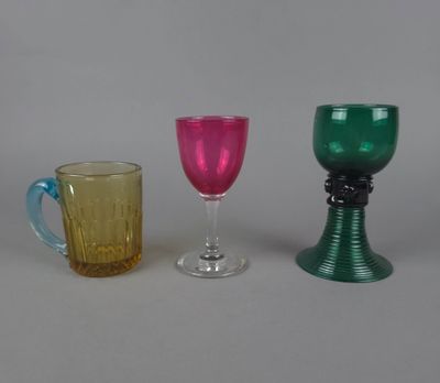 trois verres de couleurs différentes posés les uns à côté des autres sur une table