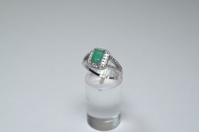 a close up of a ring with a green stone in it
