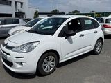 une petite voiture blanche garée dans un parking