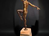 bronze sculpture of a boy on a pedestal with a ball in his hand