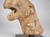 un gros plan sur une sculpture représentant une tête de lion la gueule ouverte