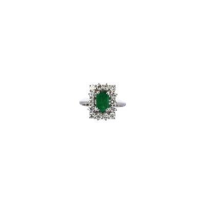 gros plan d'une bague en diamant et émeraude sur fond blanc