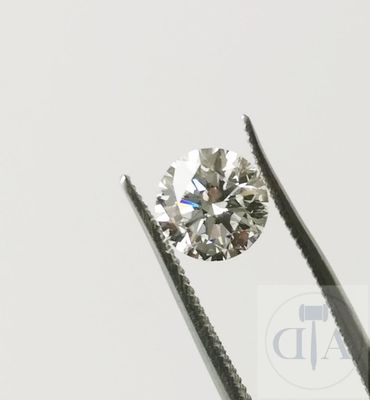 un gros plan d'un diamant tenu par une pince