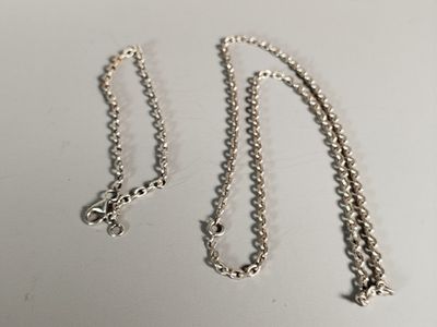 a close up of a silver chain with a cross on it