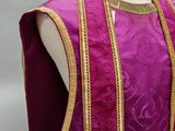 a mannequin wearing a purple vest with gold trims