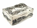 a silver box with a dragon on it on a white surface