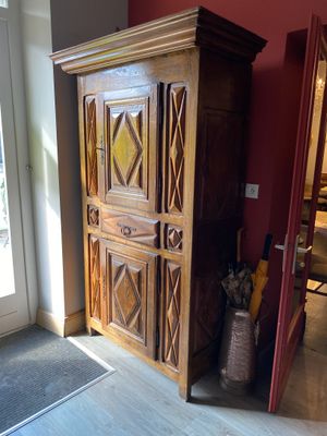 un grand meuble en bois dans le coin d'une pièce
