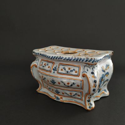 a white vase with a blue and orange design on it