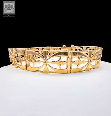 an image of a gold bracelet sitting on top of a white surface