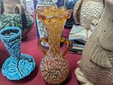 many vases on a table with a red table cloth