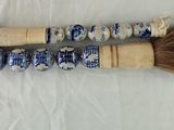 two brushes with blue and white designs on them sitting on a white surface