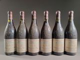 six bottles of wine are lined up in a row on a table