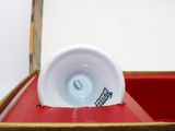 a white cup sitting on top of a red box