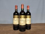 three bottles of wine sitting on top of a wooden table