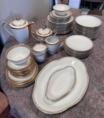 une table sur laquelle se trouvent beaucoup d'assiettes et de bols