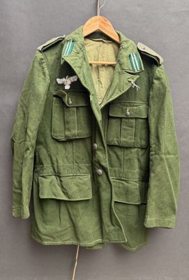 an old military jacket hanging on a hanger on a wall