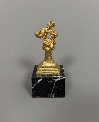 une image représentant une statue en or d'un homme posée sur un socle en marbre