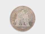 an old silver coin with a statue of a woman and a man on it