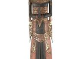 une vieille statue en bois d'un homme avec un chapeau sur la tête
