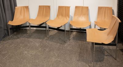 four chairs are lined up against a wall in a room
