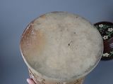 a person holding a large drum in their hand
