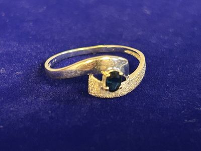 a close up of a gold ring with a green stone on it