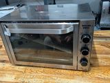 a toaster oven sitting on a wooden table in a kitchen