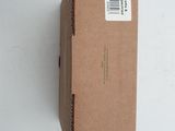 an open box with a sticker on it sitting on a white surface