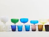 many different colored glasses lined up on the table