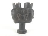 a wooden sculpture of two heads on a white background