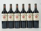 six bottles of red wine lined up in a row on a table