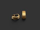 une paire de boucles d'oreilles en or sur fond noir