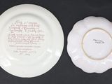 two white plates with writing on them sitting on a black surface