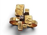 une image d'une bague en or et en diamant sur une surface blanche