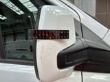 a white car with a sticker on it ' s side mirror